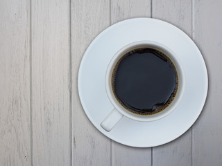 A cup of coffee on white wooden background