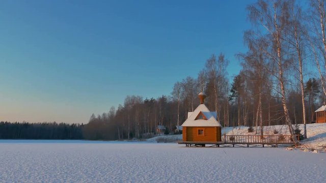 Small Wooden Chapel in a Sunny Snowy Winter Day