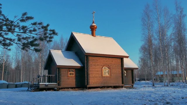 Small Wooden Church in a Sunny Snowy Winter Day