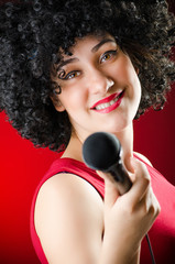 Woman with afro hairstyle singing in karaoke