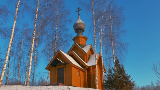 Small Wooden Church in a Sunny Snowy Winter Day