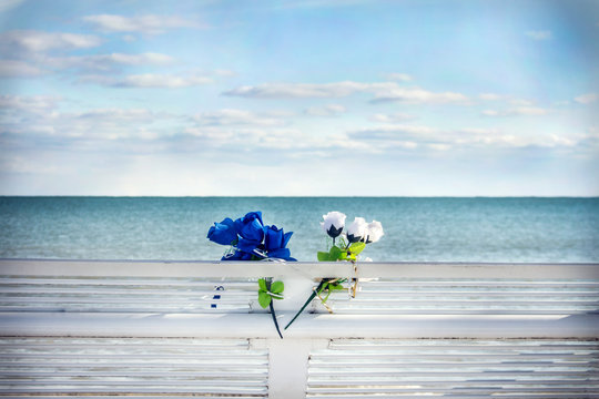 Blue and white flowers on a bench overlooking a lake landscape