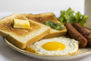 healthy breakfast fried egg yellow yolk, toast bread, sausage, vegetable in morning,  delicious sandwich diet lunch