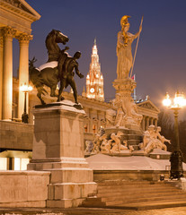 Fototapeta na wymiar Vienna - Pallas Athena fountain and parliament in winter evening