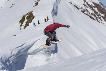Naklejka na ściany i meble Snowboard rider jumping on mountains. Extreme snowboard freeride.