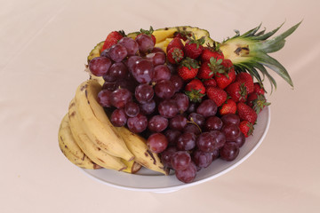 grapes, pineapple, bananas and fresh strawberries on the plate