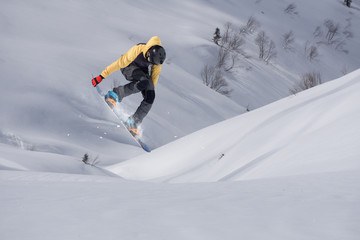 Snowboard rider jumping on mountains. Extreme snowboard freeride.