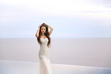 Fototapeta na wymiar Beautiful fashion bride girl in beaded wedding dress. Summer hol