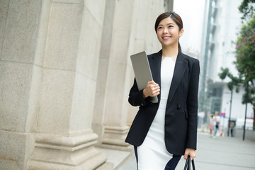 Business woman hold with notebook computer and walking at street