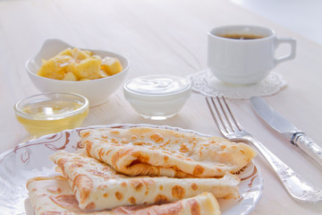 Breakfast. Pancakes, a cup of black coffee, honey and apples flambé