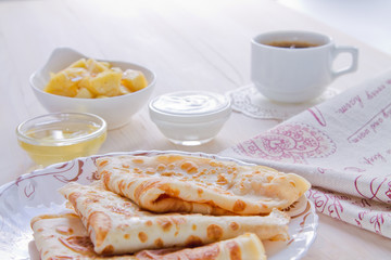 Breakfast. Pancakes, a cup of black coffee, honey and apples flambé