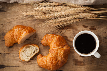 Tasty croissant and coffee still life rustic