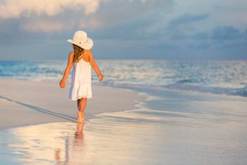 Little girl walking on beautiful ocean beach