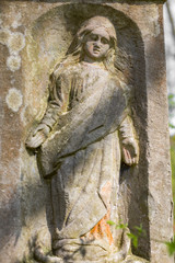 Fototapeta na wymiar Engraved sculpture of saint on grave