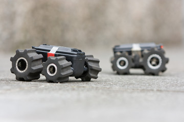 Two toy cars on a ground ready for a test-drive. Activities and games with children outdoors. miniature vehicles on remote control