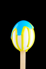 Egg on a wooden stick drenched colors