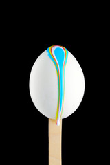 Egg on a wooden stick drenched colors