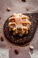 Belgian sugar waffles with grated nuts and caramel syrup