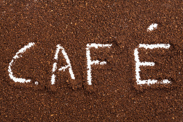 La palabra caf&eacute; escrita con caf&eacute; molido sobre una mesa
