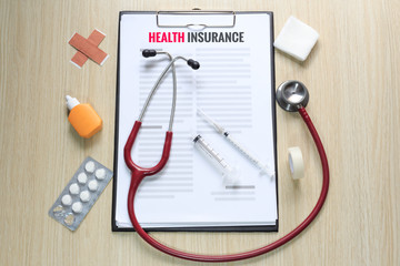 Top view of health insurance policy with stethoscope, hypodermic
