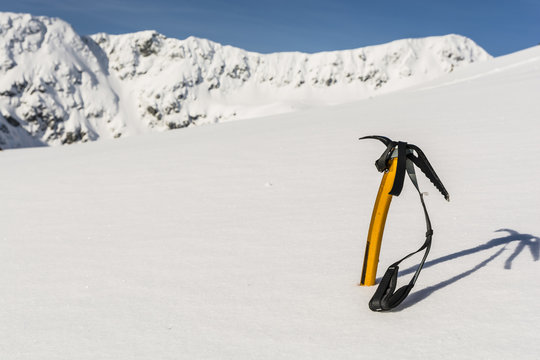 Ice axe stuck in the snow on the slopes.