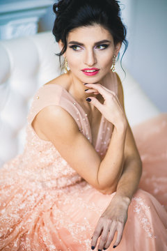 Portrait of beautiful young brunette woman in gorgeous fashionable dress