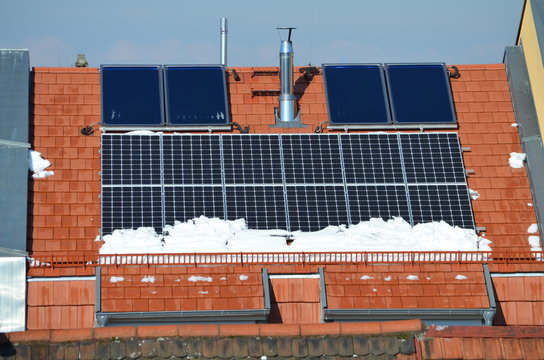 Photovoltaik-Anlage auf einem Hausdach im Winter