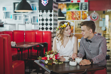 A young couple sitting in a cafe at a table 5869.