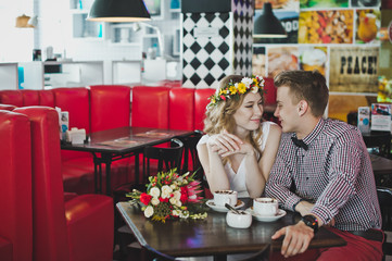 A young couple sitting in a cafe at a table 5870.