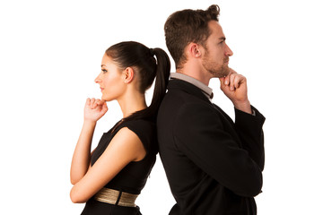 Confident business couple leaning on each other with backs, hold
