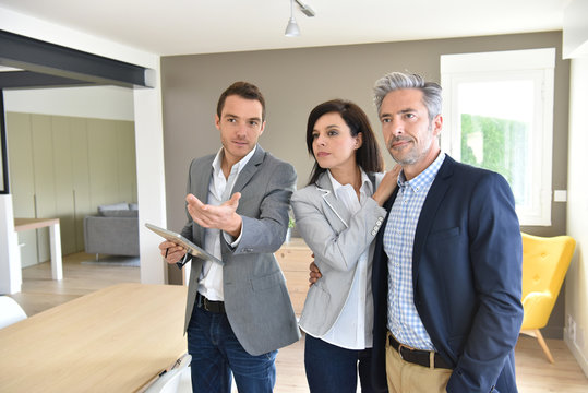 Mature couple with real-estate agent visiting new house