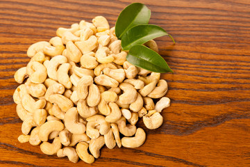 Heap of cashew nuts, healthy snack on wooden background.