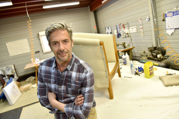 Portrait of successful upholsterer in workshop