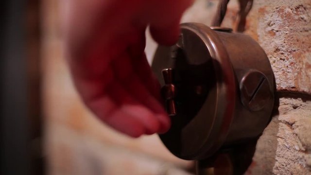 Man's hand turns on the light
