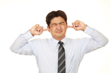 耳をふさぐ男性