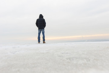 Back view of man standing on snow and watching nature