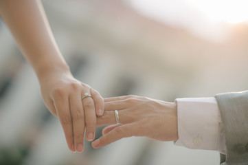 close up bride groom holding hand with sunset (selective focus)
