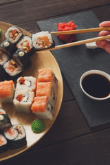 Set of sushi maki and rolls at black rustic wood.