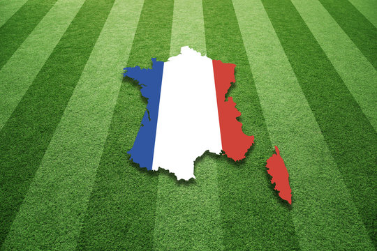 Sunny socccer artificial green grass field with France map in flag colors background.