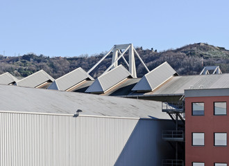 Industrial area on the outskirts with hills on the horizon.