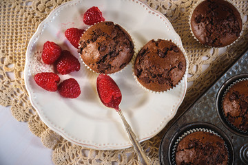 Chocolate muffins with red juicy raspberries