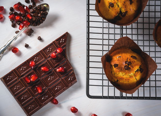 Chocolate muffins with a chocolate bar and red pomegranate fruit