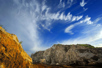 Obraz premium Title : Yellow Rock and Cloud Formation Description : Beautiful landscape of cloud formation over yellow rock makes combination of blue and yellow colors
