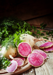 Cut pink radish, vintage wooden background, selective focus