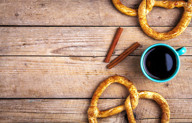 Delicious Breakfast, a pretzel with coffee on wooden background.