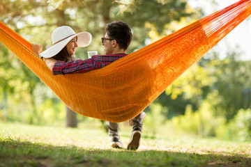 Young man and girl in hammock from back