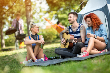 Young people enjoys on excursion with beer and guitar