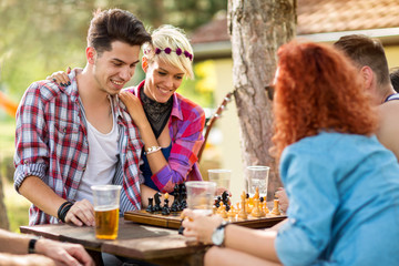 Guy play chess with opponent at camp