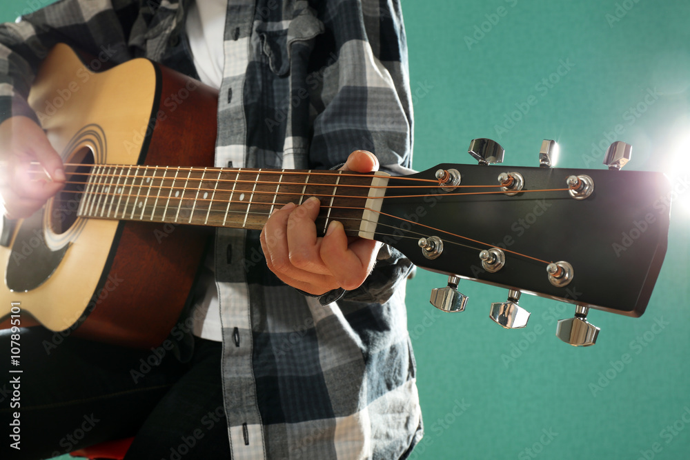 Wall mural musician plays guitar on blue background, close up