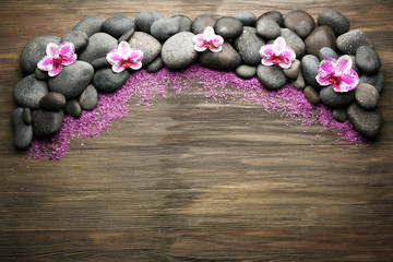 Spa stones and orchid on wooden background